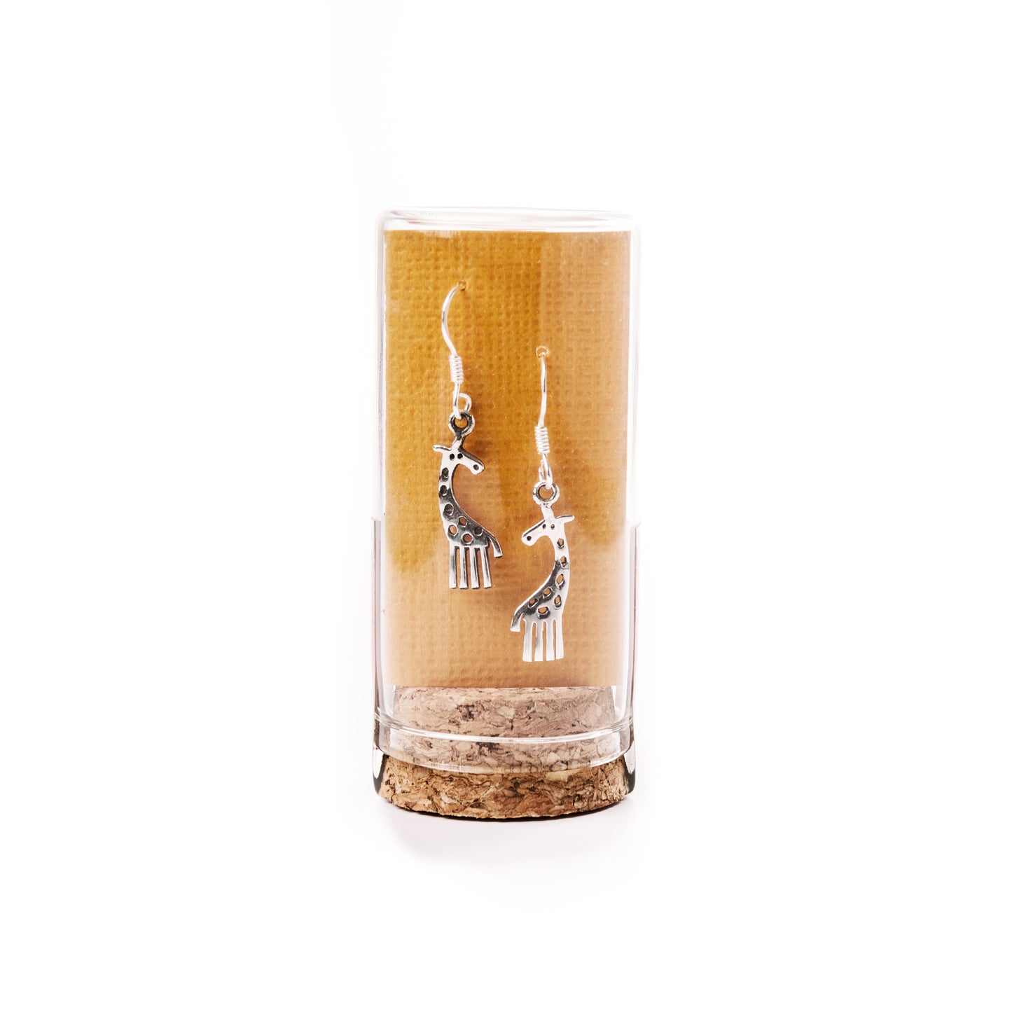 Silver giraffe-shaped earrings in a clear cylindrical container with cork base on a white background